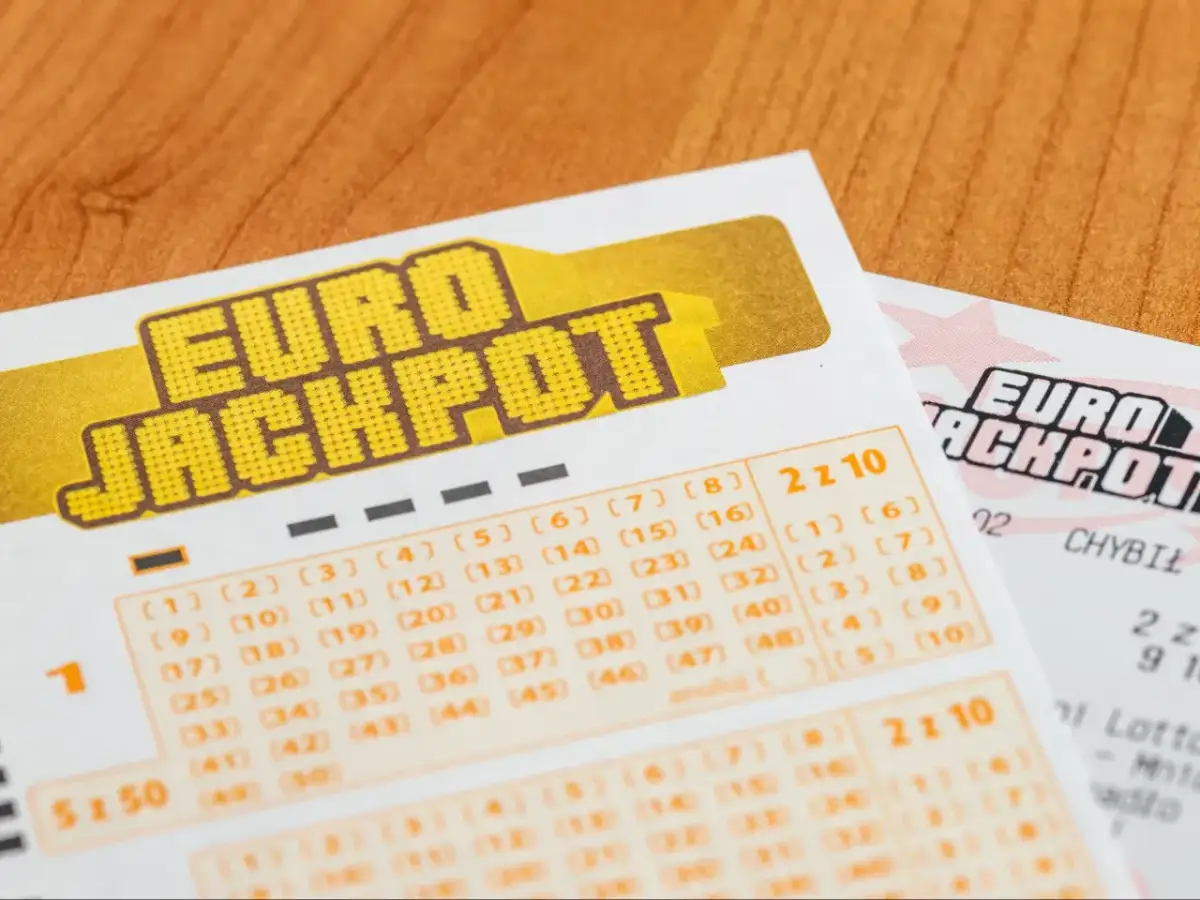 Kupony gry liczbowej Eurojackpot na drewnianym tle.