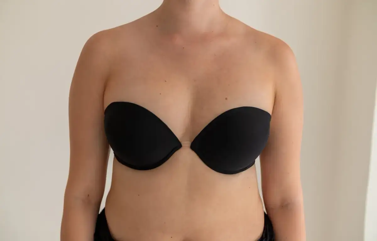 Kobieta w czarnym, bezszwowym biustonoszu typu push-up z przezroczystym mostkiem.
