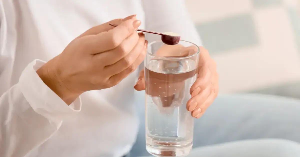 Kobieta dodaje miarkę kolagenu końskiego dla ludzi do szklanki wody.