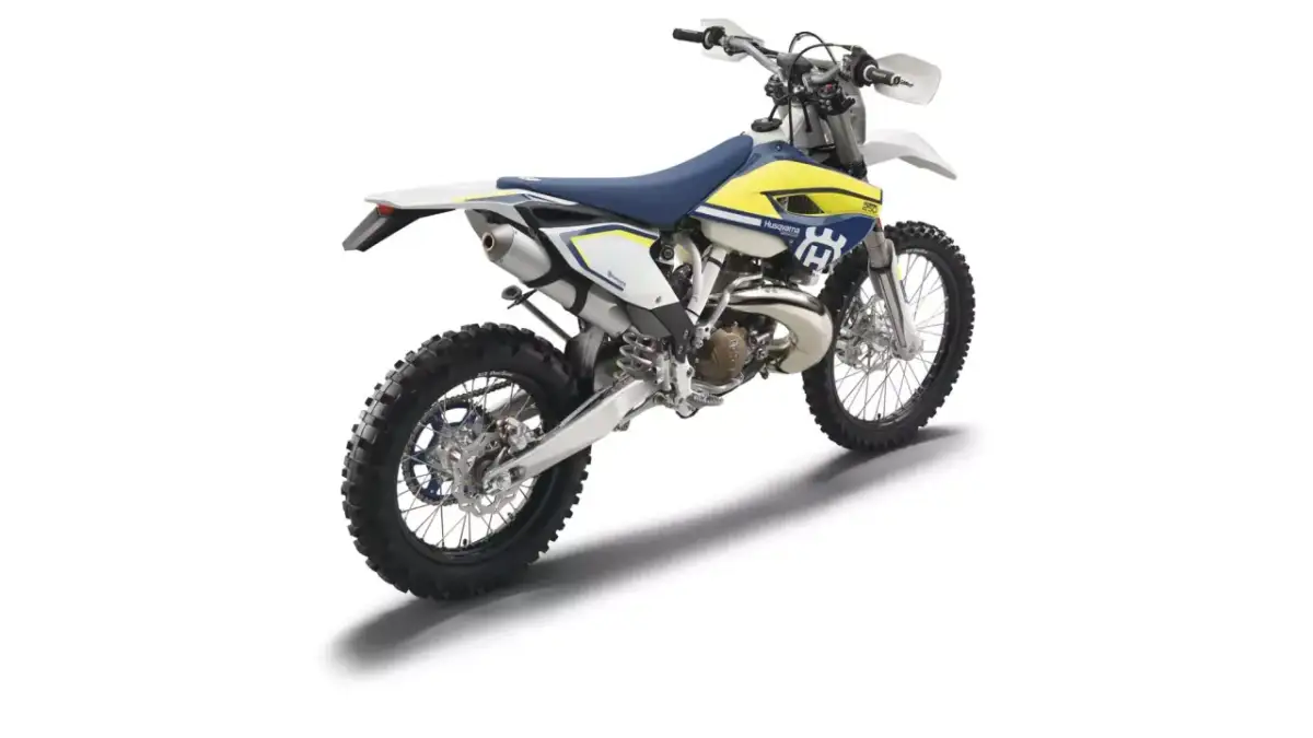 Husqvarna TE 250 gotowy do jazdy po bezdrożach. Biało-żółty motocykl terenowy z niebieskim siedzeniem.