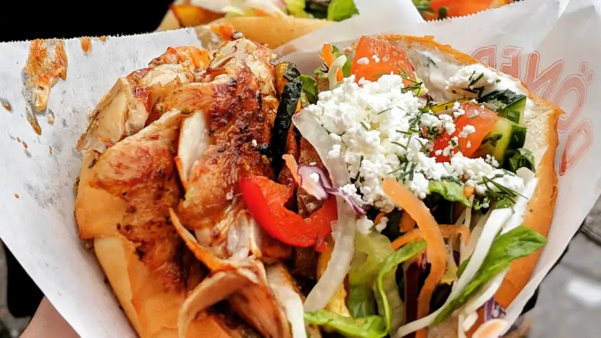 Kebab z kurczakiem, warzywami i serem feta w bułce.