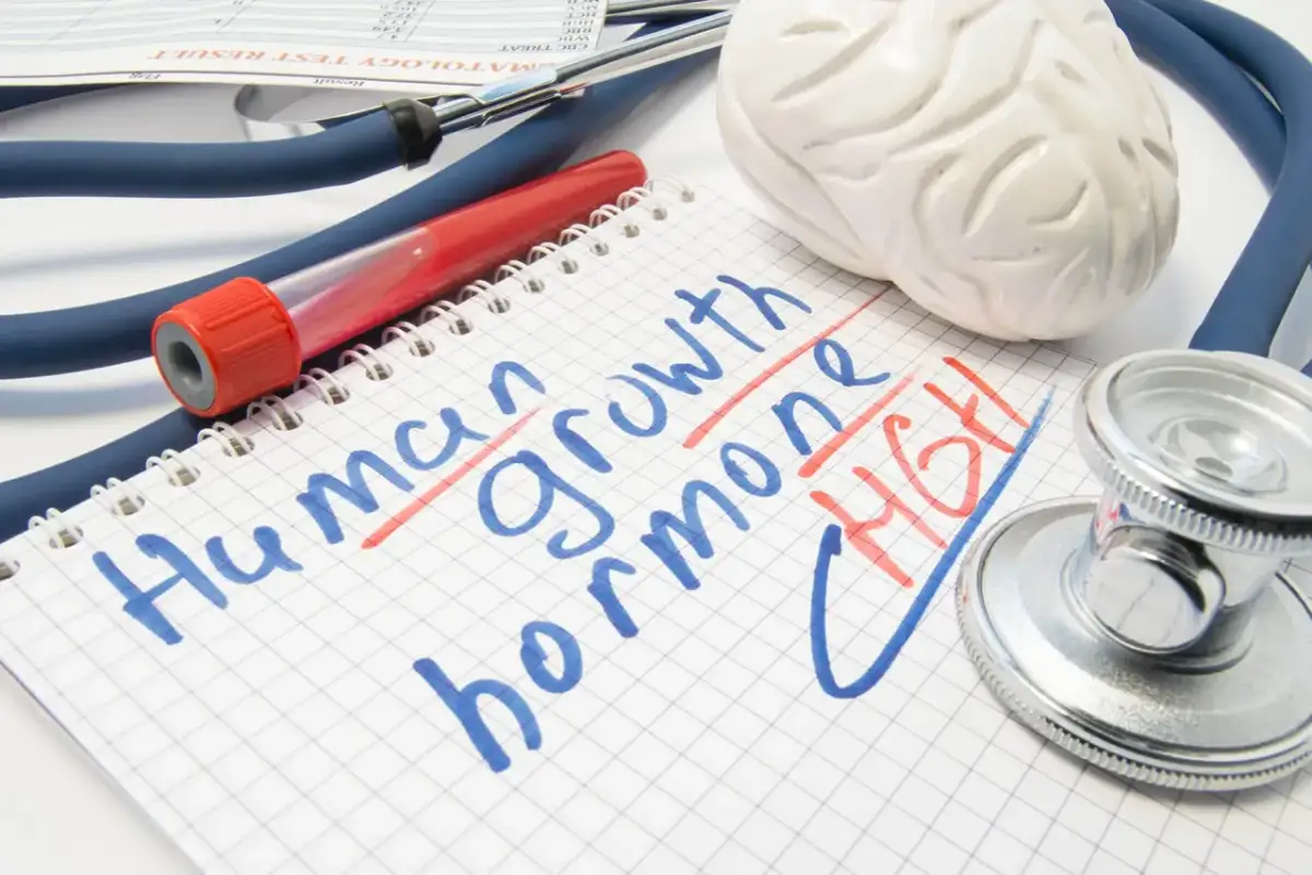 Czy hormon wzrostu jest sprzedawany w aptekach? Stetoskop, probówka i notatnik z napisem "Human growth hormone" sugerują medyczne zapytanie.