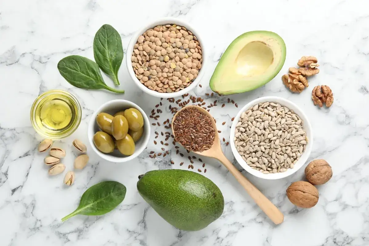 Różnorodne tłuszcze roślinne: awokado, oliwki, orzechy, nasiona, soczewica i olej.