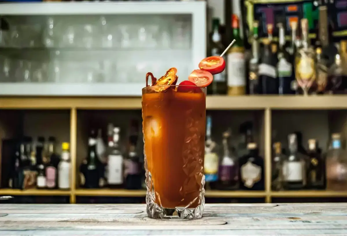 Orzeźwiający drink Krwawa Mary z pomidorkami i suszonymi papryczkami, gotowy do podania na barze.