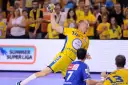 Piłkarz ręczny w żółtej koszulce z numerem 14 rzuca piłkę podczas eliminacji mistrzostw europy w piłce ręcznej grupa polska.