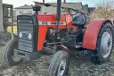 Czerwony ciągnik Ursus 3512 z czarną maskownicą i siedzeniem, stojący na ziemi.