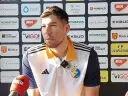 Daniel Dujshebaev w koszulce z herbem klubu, przed ścianką sponsorską z logo "Industria Kielce".