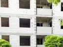 Budowa bloku mieszkalnego, widoczne puste okna i balkony. W przyszłości powstanie tu mieszkanie komunalne.