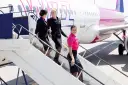 Uśmiechnięte stewardessy Wizz Air schodzą po schodkach. Ciekawe, ile zarabia stewardessa Wizz Air za taką pracę?