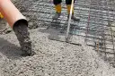 Wylewanie betonu na zbrojenie fundamentów.