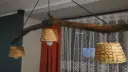 Jak odnowić stary drewniany żyrandol? Ta rustykalna lampa z gałęzi i plecionych kloszy z pewnością doda uroku wnętrzu.