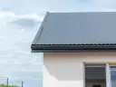 Nowoczesne opierzenie dachu z blachy falistej, chroniące dom przed deszczem.