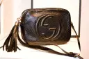 Czarna, pikowana torebka Gucci z wytłoczonym logo i frędzlami. Klasyczne, stylowe modele torebek Gucci.