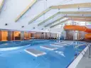 Wodne szaleństwo w hotelu z basenami w górach: zjeżdżalnia, jacuzzi i dmuchane wyspy na wodzie.