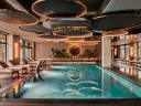 Nowoczesny basen SPA z leżakami i designerskim sufitem.