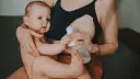 Mama karmi piersią i odciąga pokarm, pokazując, jak karmienie piersią a praca mogą iść w parze.