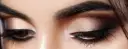 Nahaufnahme von Augen mit dezentem, strahlendem Make-up in Gold- und Brauntönen.
