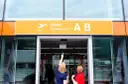 Dwie kobiety patrzą na tablicę "Odlocoty A B" na Lotnisku Chopina. Zastanawiają się, ile kosztuje parking na lotnisku Chopina.