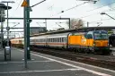 Pociąg Berlin Warszawa Express z żółto-niebieską lokomotywą na peronie.