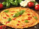 Pyszna pizza z kalafiora, z ciągnącym się serem i świeżą bazylią, otoczona pomidorami i różyczkami kalafiora.