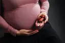 Kobieta w ciąży trzyma w dłoni garść daktyli. To naturalny sposób na wsparcie organizmu w tym wyjątkowym czasie.