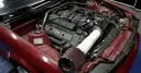 Czerwony silnik BMW z widocznym filtrem powietrza i elementami tuningu.