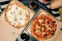Dwie pyszne pizze: jedna biała z kiełbasą i ziemniakami, druga czerwona z oliwkami i karczochami. Takie są pizze na wieczór!