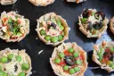 Mini pizze z groszkiem, oliwkami i serem, idealne na podwieczorek.