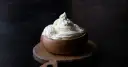 Kremowa masa w drewnianej miseczce, idealna do deserów. Mascarpone kontra serek homogenizowany – który wybierzesz?