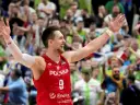 Bartosz Szczepanik w koszulce z numerem 9, z podniesionymi rękami, świętuje zwycięstwo na tle rozentuzjazmowanych kibiców.