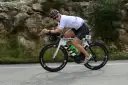 Zawodnik na rowerze triathlonowym pokonuje długi Ironman dystans, pędząc po górskiej trasie.