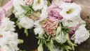 Delikatne, pastelowe rodzaje bukietów we florystyce: białe róże, pudrowy goździk i różana róża tworzą romantyczną kompozycję.
