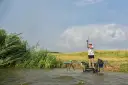 Wędkarz zmagający się z wiatrem, z napiętą wędką, gotowy do rzutu feederem do dalekich rzutów.