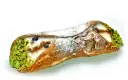 Sycylijski cannolo z kremem, pistacjami i borówkami, posypany cukrem pudrem.