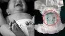 Jak założyć pampersa chłopcu? Zdjęcie pokazuje stopy dziecka i zużytą pieluchę z zielonym wkładem i ciemnymi grudkami.