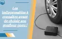 Gonfleur de pneu noir connecté à une roue de voiture sur fond gris.