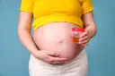 Kobieta w ciąży trzyma pojemnik z próbką moczu, badanie na obecność ketonów w moczu w ciąży.