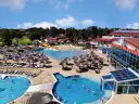 Aquapark w Jarosławcu: baseny, zjeżdżalnie i leżaki pod parasolami. Wiele osób korzysta z atrakcji, tworząc radosną atmosferę.