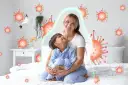 Mama tuli dziecko, które miało kaszel w nocy. Wokół nich wirusy, ale chroni je zielona bariera.