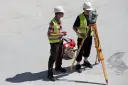 Dwóch geodetów pracuje na budowie. Zastanawiasz się, ile zarabia geodeta w Niemczech?