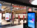 Sklep Vision Express z ekspozycją okularów i ekranem informacyjnym.