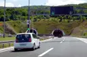 W Chorwacji są płatne autostrady. Biały samochód zbliża się do tunelu, sygnalizacja świetlna zielona.