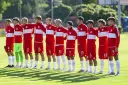 Drużyna Polski na Mistrzostwach Europy do lat 17. Piłkarze w czerwonych strojach z białymi pasami stoją w rzędzie, gotowi do meczu.