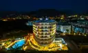 Nocny widok na lśniący hotel Michell z basenem i oświetlonymi pokojami. Wiele pozytywnych michell hotel spa opinie potwierdza jego urok.
