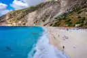 Widok z lotu ptaka na plażę Myrtos na Kefalonii z turkusową wodą i stromym klifem.