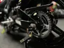 Zbliżenie na tylne koło motocykla, widoczny napęd i łańcuch, gotowy do czyszczenia łańcucha motocyklowego.