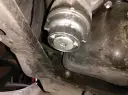 Filtre à huile de voiture sous le véhicule, avec une clé carrée insérée.