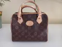 Brązowa louis vuitton torebka kuferek z monogramem. Elegancka, z jasnymi rączkami i detalami.