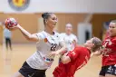 Piłkarka Suzuki Korona Handball Kielce rzuca piłkę. Rywalka w czerwonej koszulce próbuje ją zablokować.