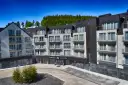 Nowoczesny apartamentowiec z balkonami, otoczony lasem. Idealne miejsce na czarna góra noclegi.